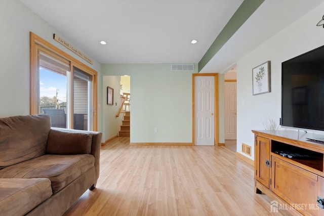 living area with stairway, light wood finished floors, baseboards, and recessed lighting