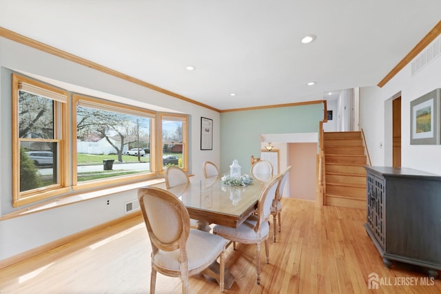 dining space with crown molding, light wood-style flooring, stairway, and recessed lighting