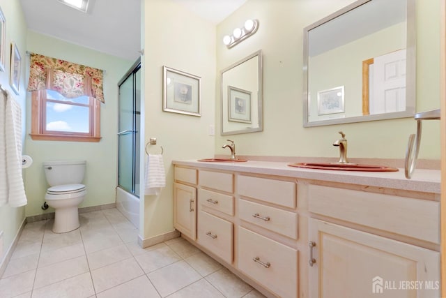 bathroom with tile patterned flooring, double vanity, toilet, baseboards, and shower / bath combination with glass door