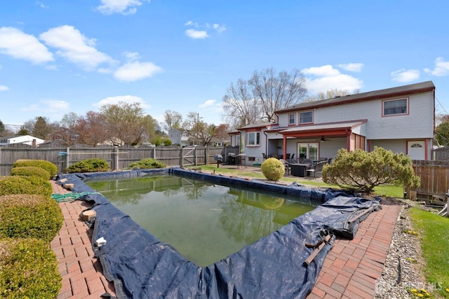 view of pool with a ceiling fan, a fenced backyard, and a patio area