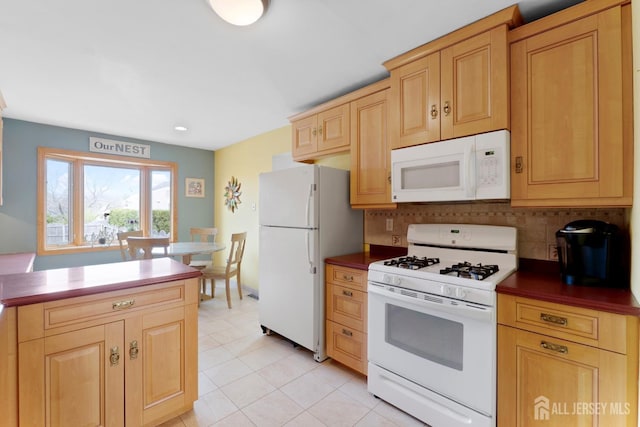 kitchen featuring white appliances, decorative backsplash, light brown cabinetry, and dark countertops