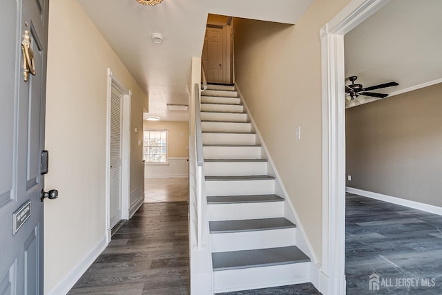 stairway with ceiling fan and wood-type flooring