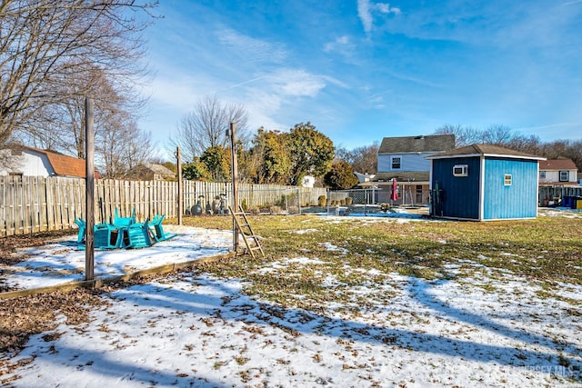 snowy yard featuring a shed