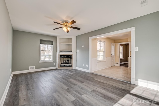 unfurnished living room featuring hardwood / wood-style floors and ceiling fan