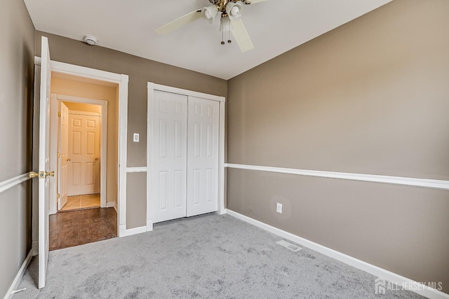 unfurnished bedroom with carpet, ceiling fan, and a closet