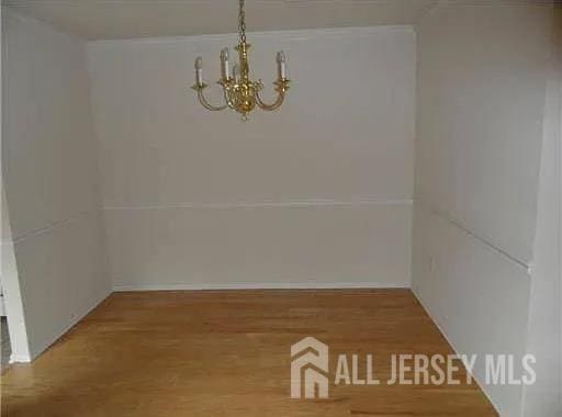 446 Great Beds Ct, Perth Amboy, NJ 08861 - unfurnished dining area with a chandelier and wood finished floors