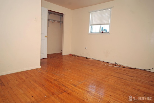 unfurnished bedroom with a closet and light wood-type flooring