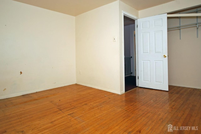 unfurnished bedroom with hardwood / wood-style floors and a closet