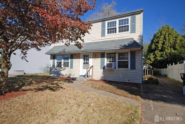 view of front of home with cooling unit and a front lawn