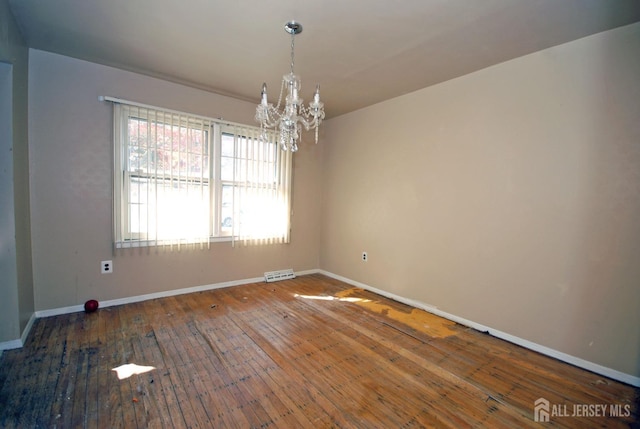 empty room featuring hardwood / wood-style flooring and a notable chandelier