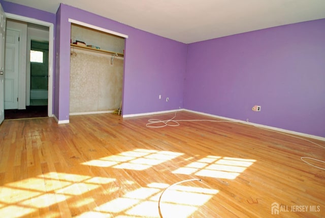 unfurnished bedroom with wood-type flooring and a closet