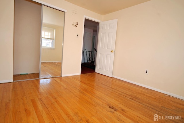 unfurnished bedroom featuring hardwood / wood-style floors and a closet