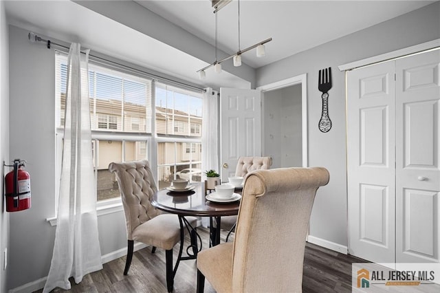 dining space with baseboards and dark wood-style flooring