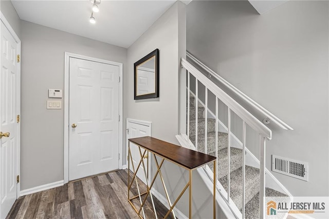 foyer entrance featuring stairs, wood finished floors, visible vents, and baseboards