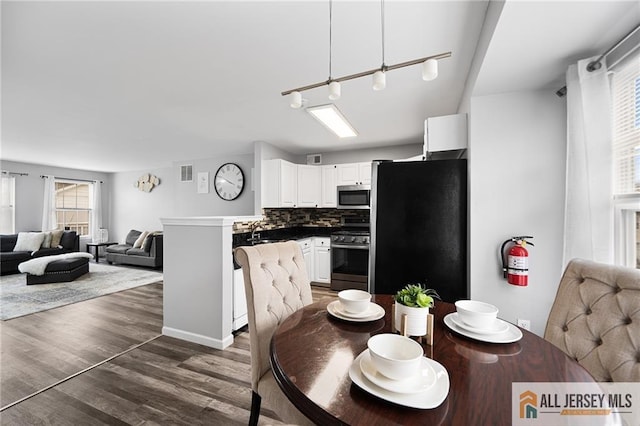 dining room featuring dark wood-type flooring and visible vents