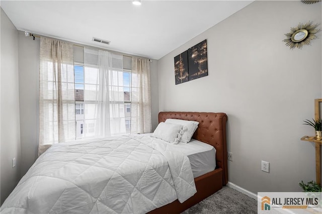 bedroom featuring carpet floors, visible vents, and baseboards