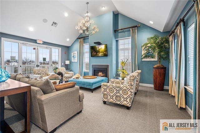 carpeted living room featuring vaulted ceiling, plenty of natural light, a glass covered fireplace, and visible vents