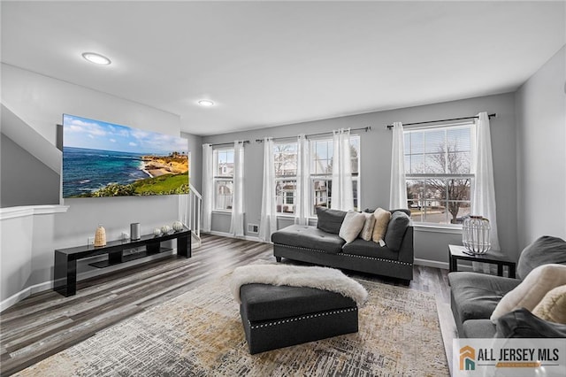 living area featuring plenty of natural light, wood finished floors, and baseboards