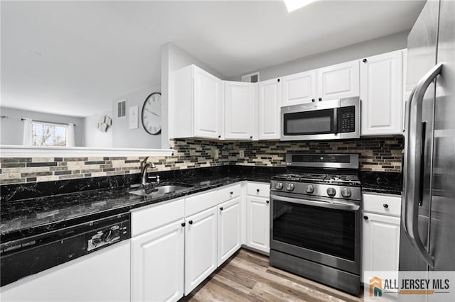 kitchen with stainless steel appliances, white cabinets, and a sink