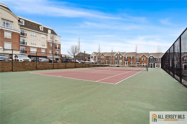 view of sport court with community basketball court, fence, and a residential view