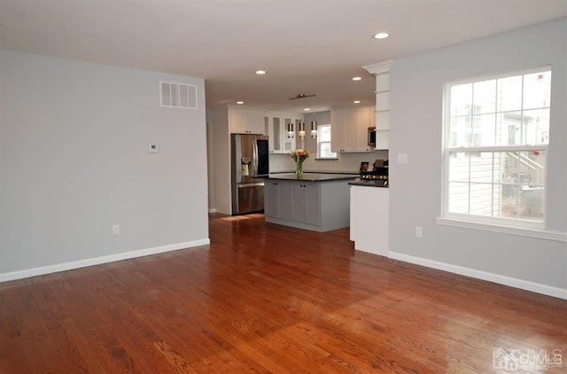 unfurnished living room featuring dark hardwood / wood-style floors and a wealth of natural light