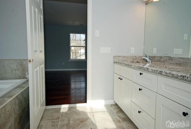 bathroom with vanity, tile patterned floors, and tiled bath