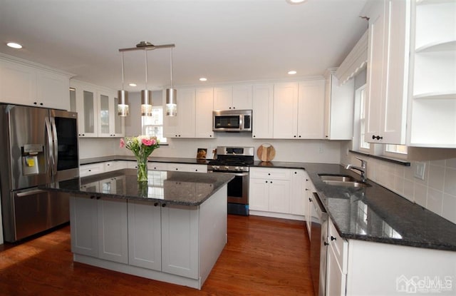 kitchen featuring white cabinetry, dark hardwood / wood-style flooring, a kitchen island, stainless steel appliances, and sink