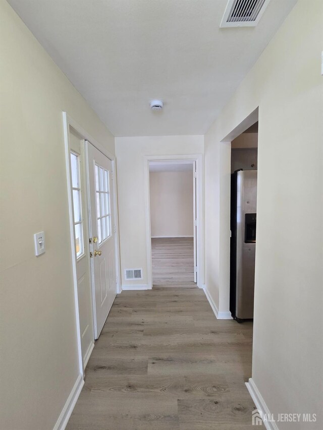 hall featuring french doors and light hardwood / wood-style floors