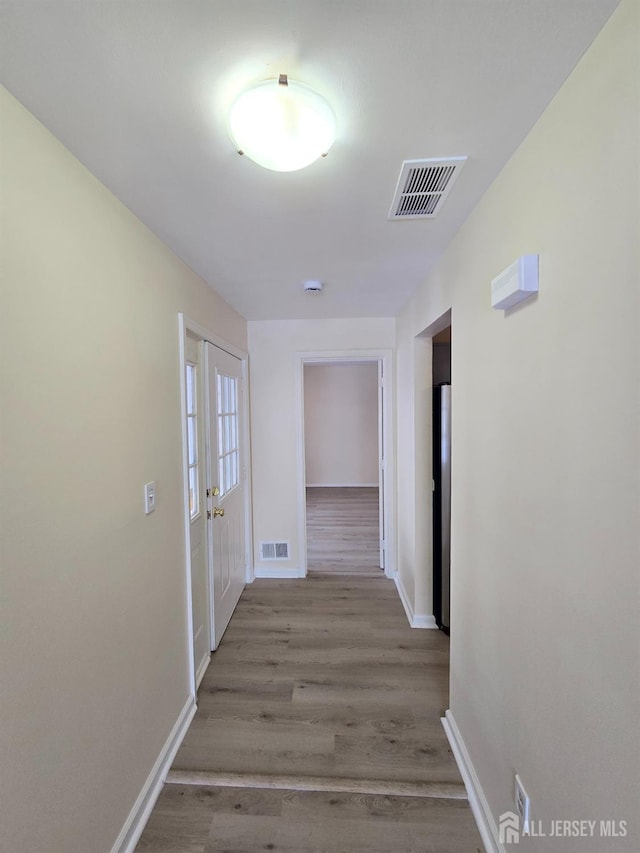 hallway featuring light wood-type flooring and french doors