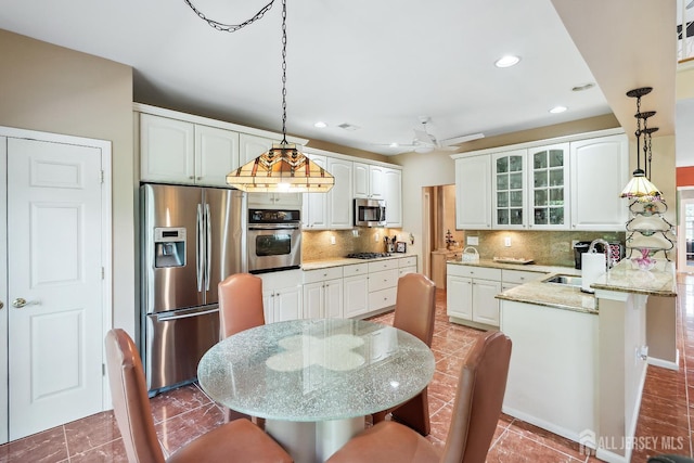 267 Tyler Ct, Monroe, NJ 08831 - kitchen with stainless steel appliances, glass insert cabinets, decorative light fixtures, a peninsula, and recessed lighting