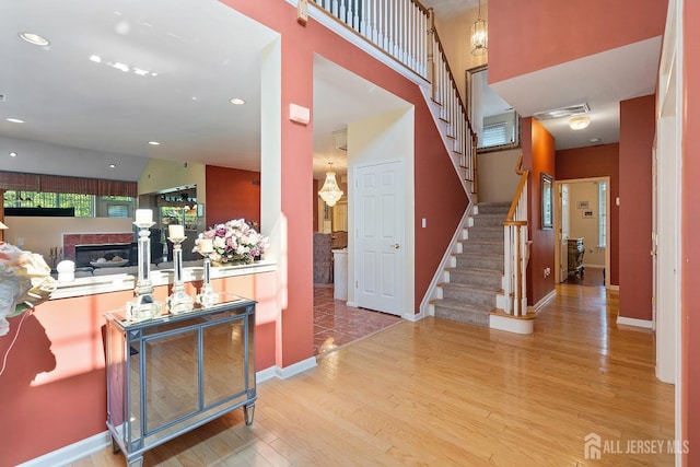 267 Tyler Ct, Monroe, NJ 08831 - entrance foyer with wood finished floors, stairway, a glass covered fireplace, a high ceiling, and recessed lighting