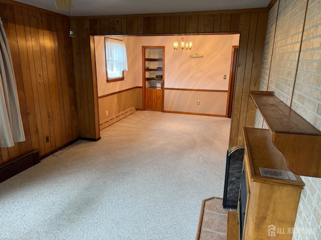 161 Manor St, South Amboy, NJ 08879 - spare room with a baseboard radiator, wood walls, carpet flooring, and a chandelier