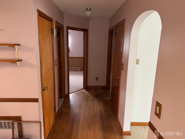 161 Manor St, South Amboy, NJ 08879 - corridor with a baseboard radiator, wood finished floors, and arched walkways