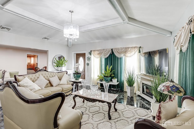 living room featuring a glass covered fireplace, beam ceiling, visible vents, and a chandelier