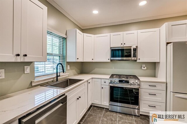 4211 Bayberry Ct, South Brunswick, NJ 08852 - kitchen with stainless steel appliances, crown molding, white cabinetry, dark tile patterned floors, and recessed lighting
