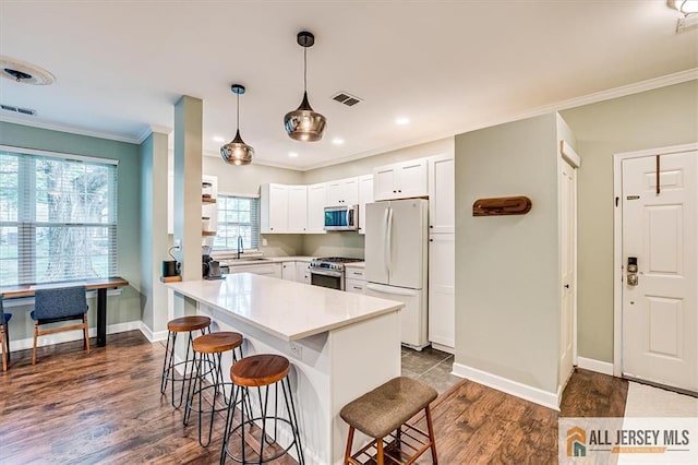 4211 Bayberry Ct, South Brunswick, NJ 08852 - kitchen featuring stainless steel appliances, a breakfast bar area, ornamental molding, light countertops, and white cabinetry