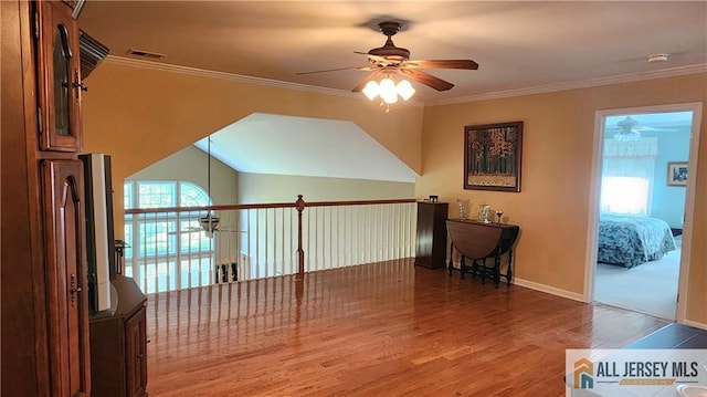 interior space with a ceiling fan, visible vents, baseboards, and wood finished floors