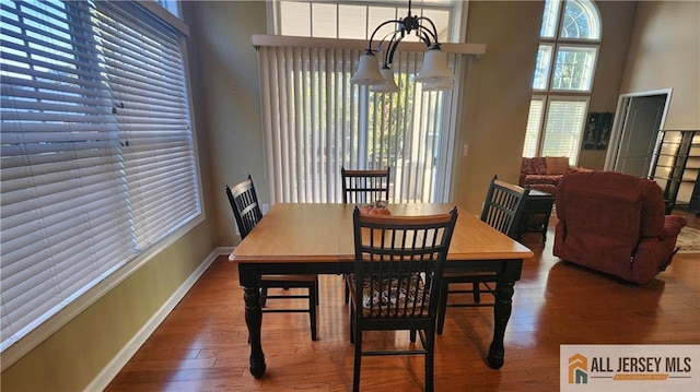 dining space featuring a towering ceiling and hardwood / wood-style floors