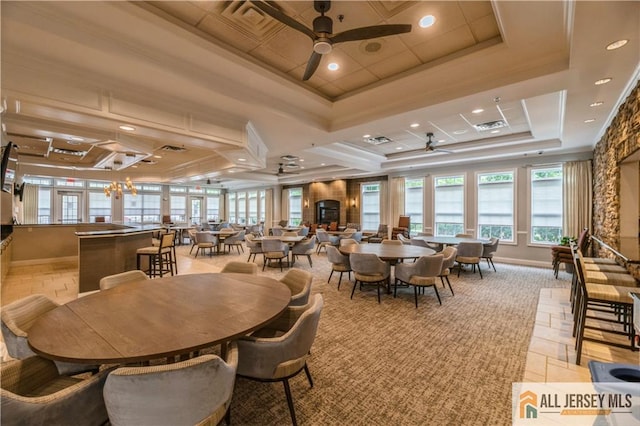 dining room with a raised ceiling, crown molding, and ceiling fan