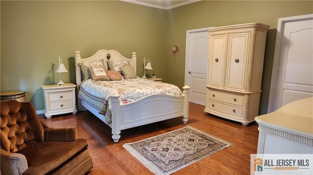 bedroom with crown molding and dark hardwood / wood-style flooring