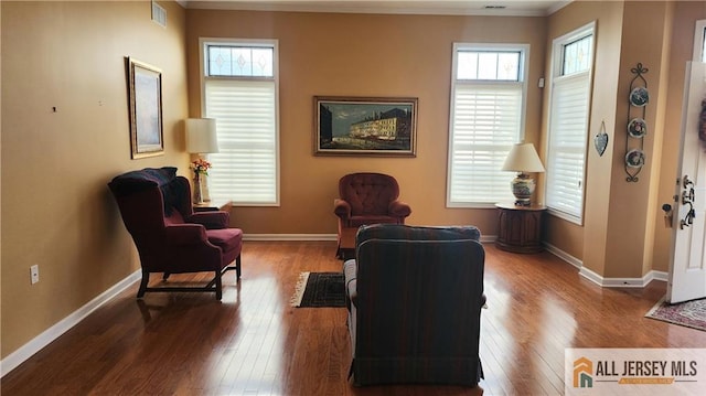 sitting room featuring wood-type flooring, visible vents, and baseboards