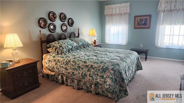 carpeted bedroom featuring multiple windows and baseboards