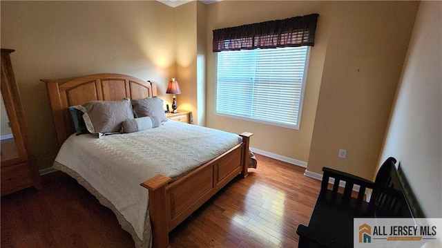 bedroom with wood-type flooring and baseboards