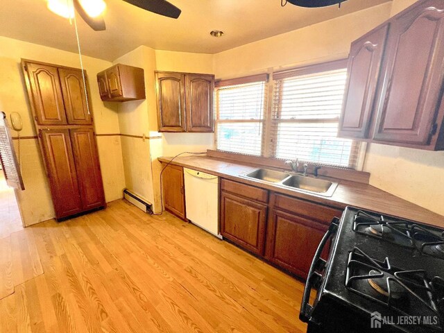 kitchen featuring light wood-style flooring, a sink, a baseboard heating unit, black gas range oven, and white dishwasher