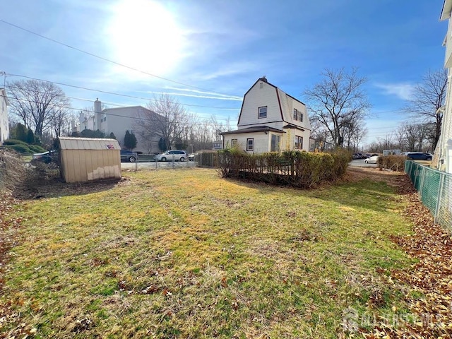 view of yard featuring a storage shed, an outdoor structure, and fence