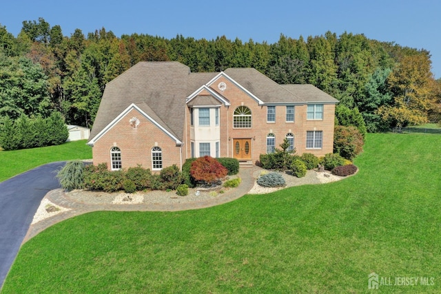 colonial inspired home with a front lawn