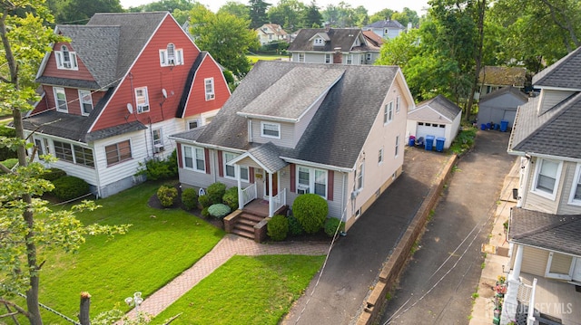 305 Penfield Pl, Dunellen, NJ 08812 - view of front of property featuring a residential view, a detached garage, a shingled roof, and a front yard