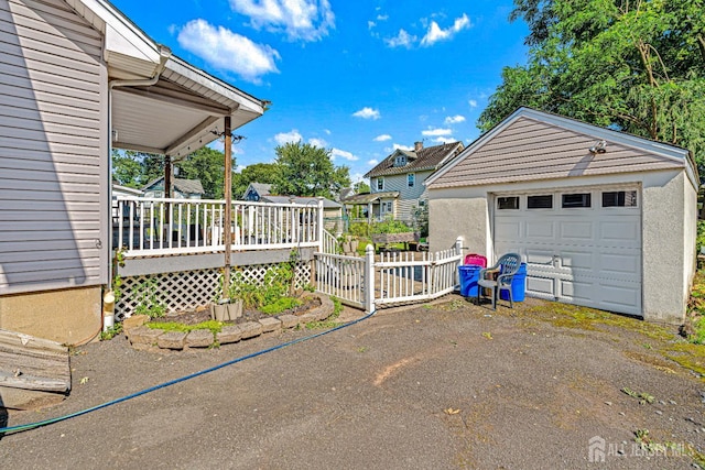 305 Penfield Pl, Dunellen, NJ 08812 - view of side of home featuring stucco siding, a detached garage, an outdoor structure, and driveway