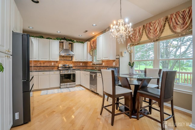 5 Fairmount Ct, Monroe, NJ 08831 - kitchen featuring stainless steel appliances, wall chimney range hood, dark countertops, white cabinetry, and a chandelier
