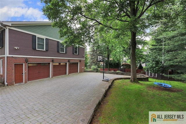 241 E Chestnut Ave, Metuchen, NJ 08840 - view of front of house featuring an attached garage, decorative driveway, brick siding, and a front lawn